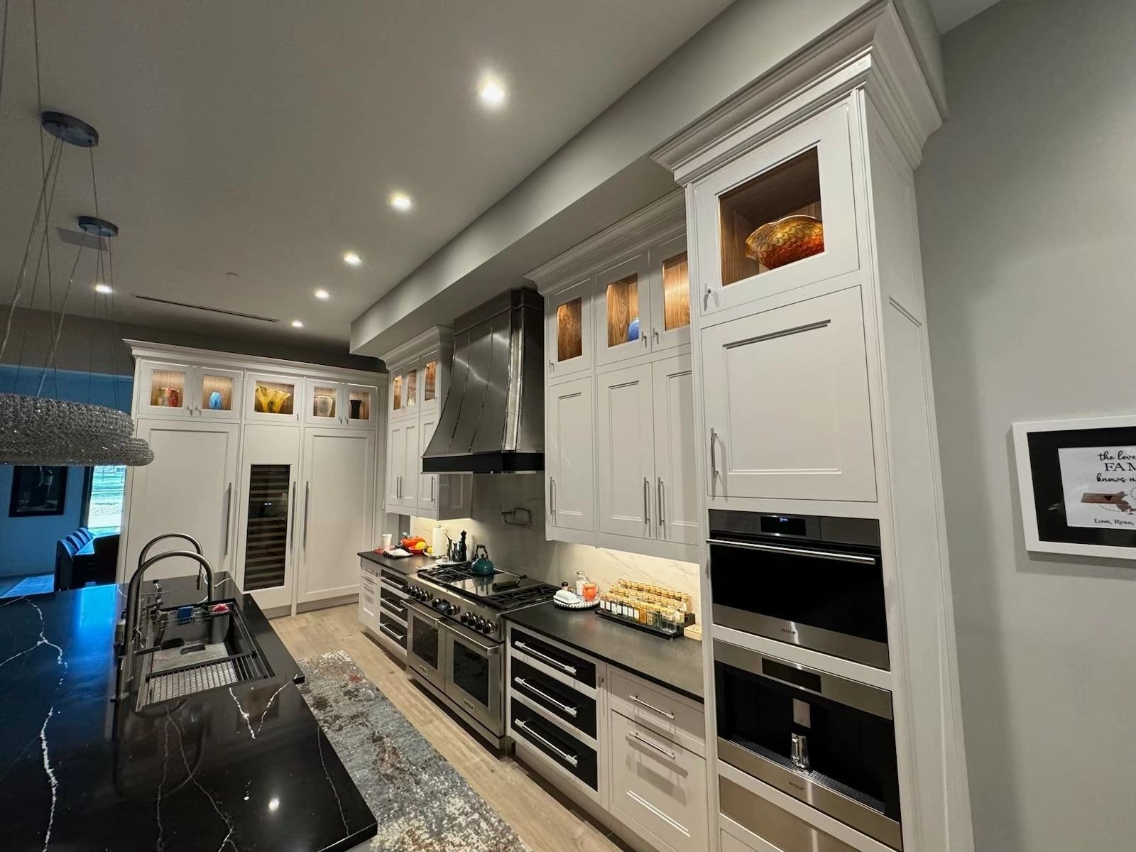 Fitted kitchen cabinetry with island seating and custom hood